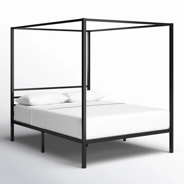 a black metal bed frame with white pillows on top and bottom, in front of a white background