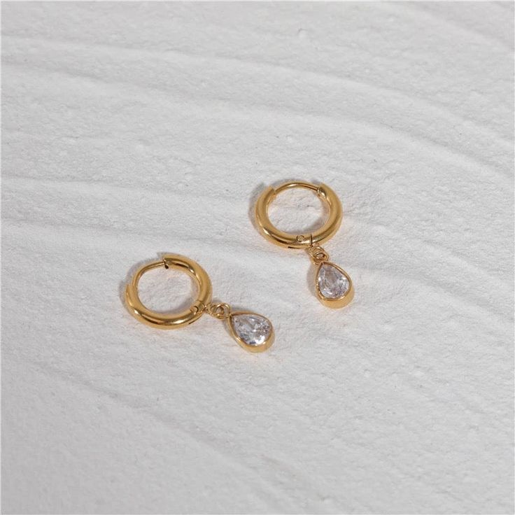 These sleek and elegant Sirena Earrings are perfect for both everyday wear and special occasions. ✅ Crafted from premium 5A grade zirconia, ensuring exceptional brilliance and durability. ✅ Meticulously manufactured using advanced techniques, guaranteeing precision and attention to detail in every aspect of design and construction. ✅ Made with hypoallergenic materials, these earrings are gentle on even the most sensitive skin, providing peace of mind and comfort for all-day wear. Classic Gold Plated Diamond Earrings, Hypoallergenic Gold Cubic Zirconia Earrings, Dainty Hypoallergenic Hoop Earrings For Formal Events, Dainty Hypoallergenic Hoop Earrings For Formal Occasions, Modern Diamond White Cubic Zirconia Huggie Earrings, Classic Cubic Zirconia Earrings With Elegant Design, Modern Huggie Earrings In Diamond White Cubic Zirconia, Elegant Huggie Earrings As A Gift For Pierced Ears, Modern Round Cubic Zirconia Huggie Earrings