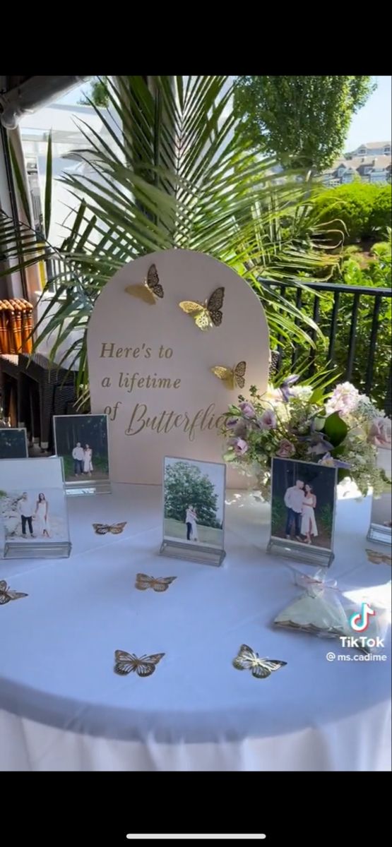 there is a table that has pictures on it and butterflies around the place setting for guests to sit at