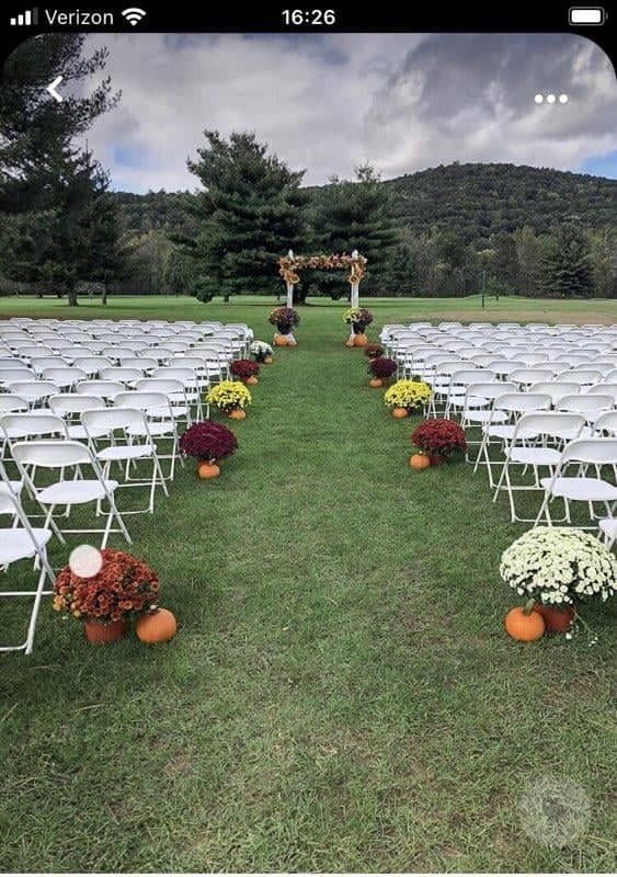 rows of chairs with flowers and pumpkins on them