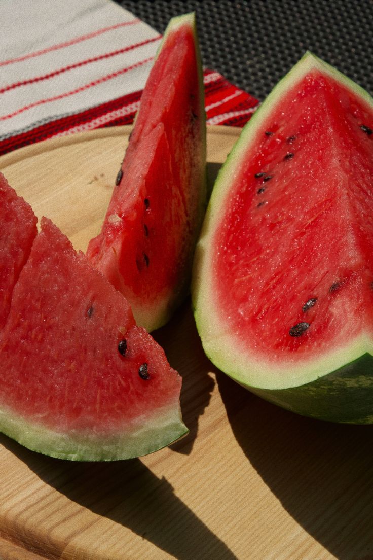 two slices of watermelon on a wooden plate