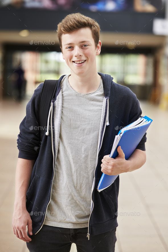 a young man holding a folder and smiling at the camera - stock photo - images