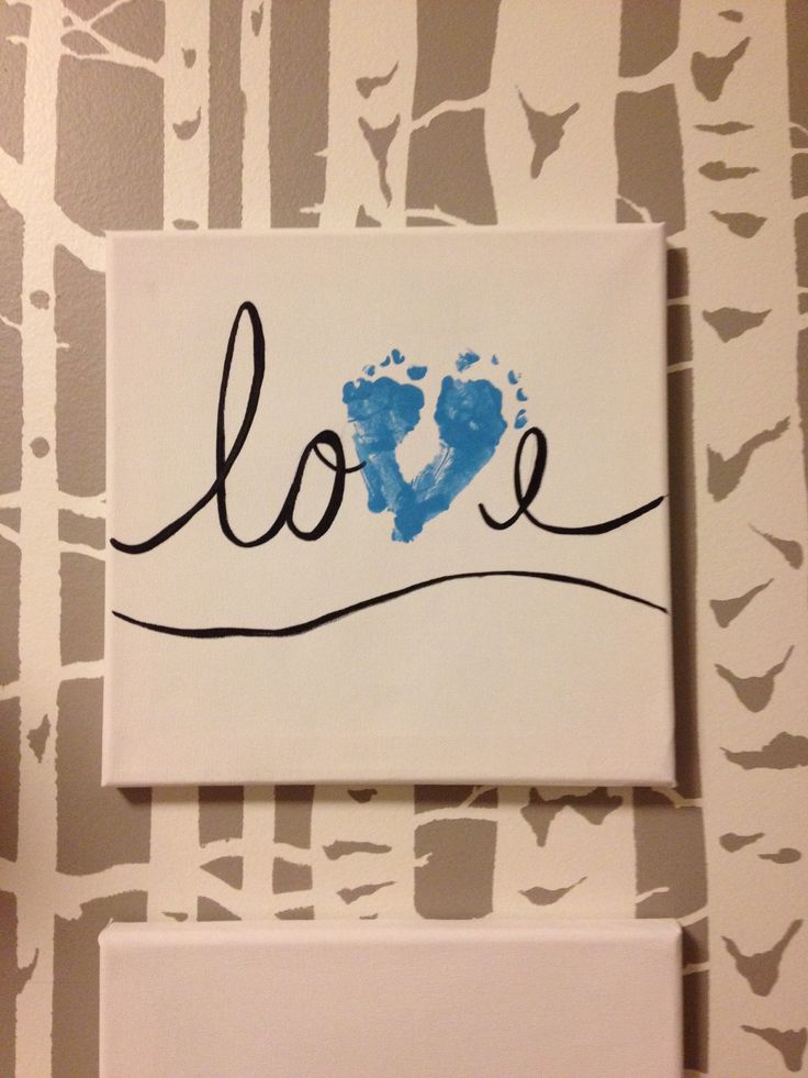 a painting with the word love painted on it next to a white wallpapered background