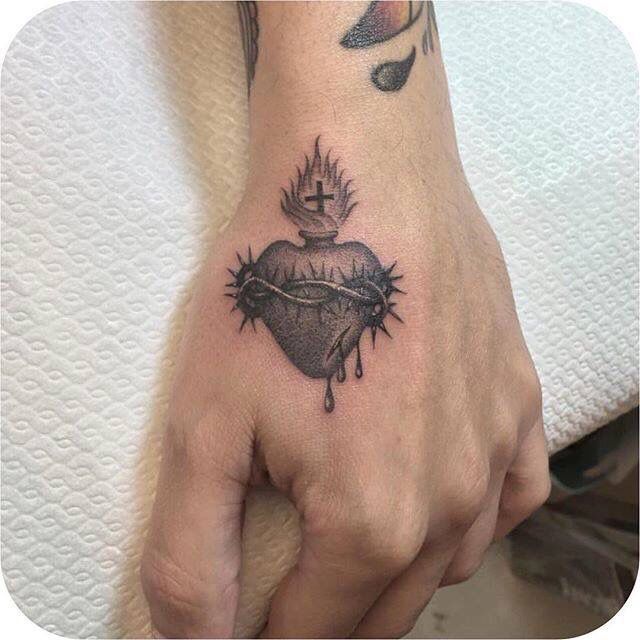 a hand with a heart and crown tattoo on it