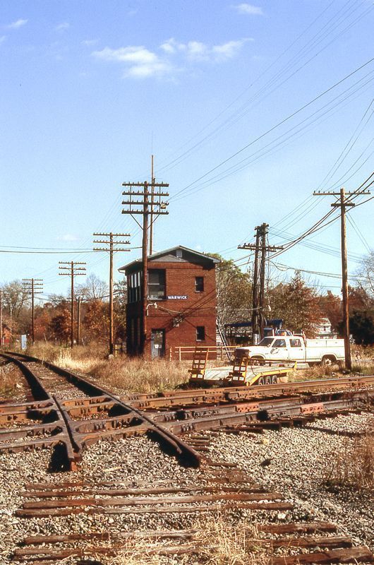 an old train track with some buildings and power lines in the backgrouds