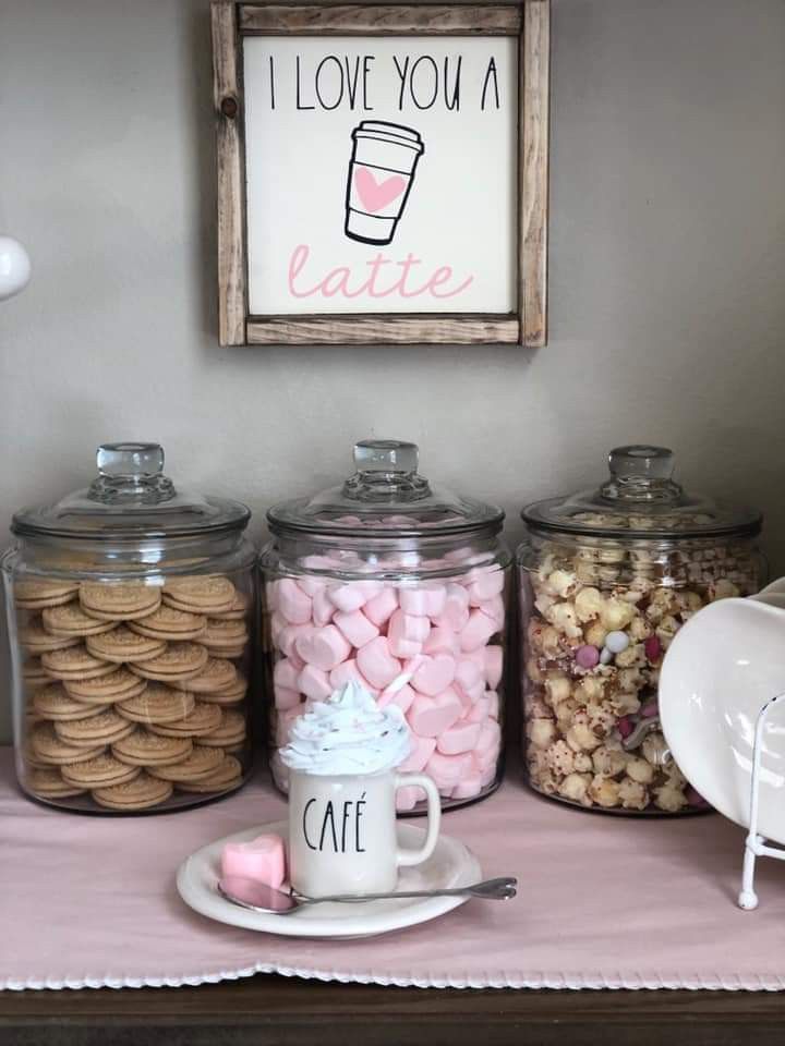 a table topped with lots of different types of candies and coffee mugs on top of each other