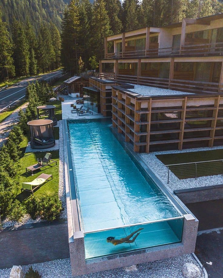 an aerial view of a swimming pool in the middle of a building surrounded by trees