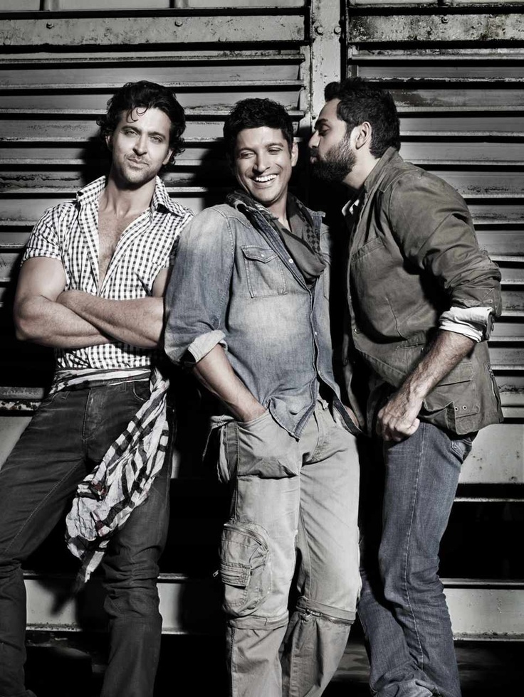 three men standing next to each other in front of a metal wall with their arms crossed