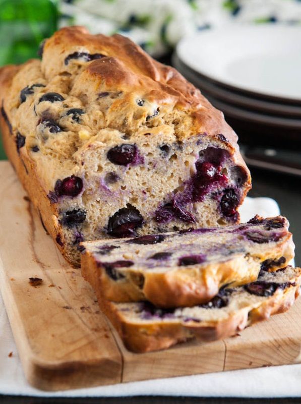 a loaf of blueberry bread sitting on top of a cutting board