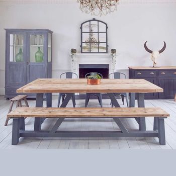 a dining room table and benches in front of a fire place with an antelope head on the wall