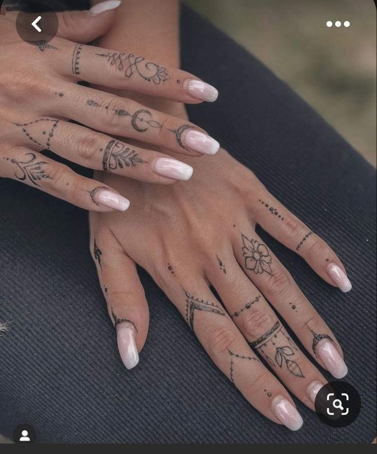 a woman's hands with tattoos on them