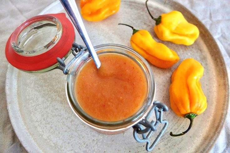 a plate topped with peppers and a jar filled with sauce