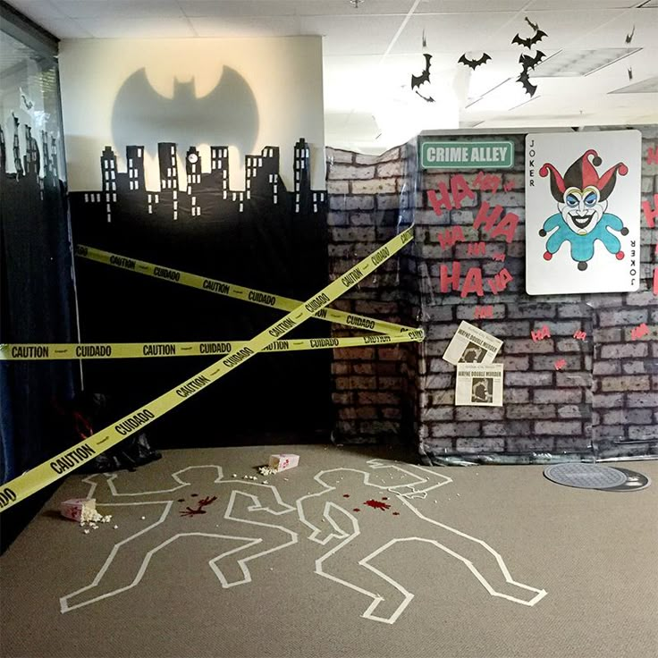 an office decorated for halloween with caution tape and fake bats on the wall behind it