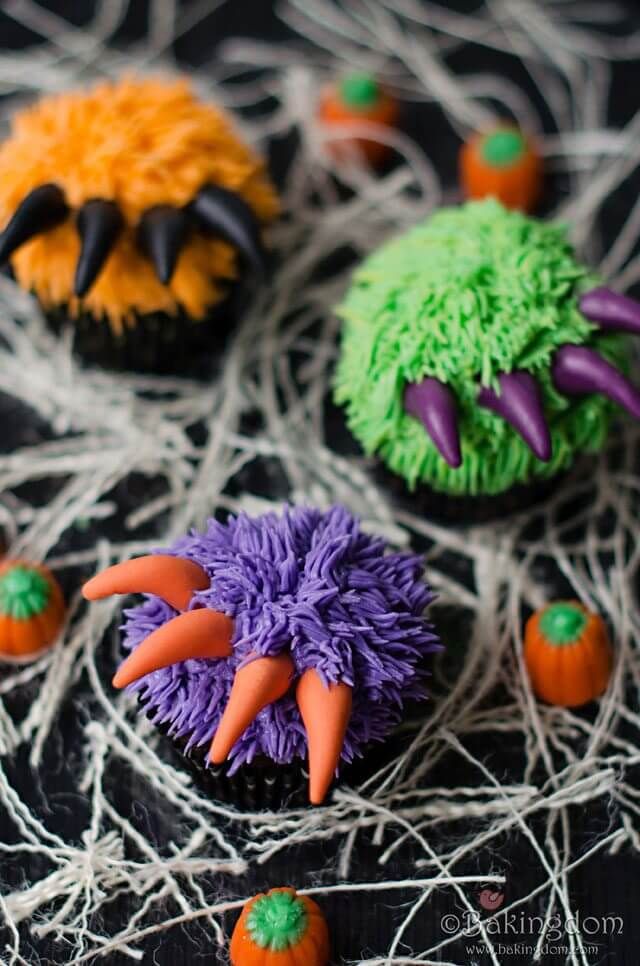 cupcakes decorated with icing and decorations on a table