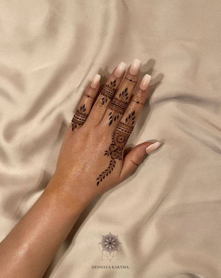 a woman's hand with henna tattoos on it