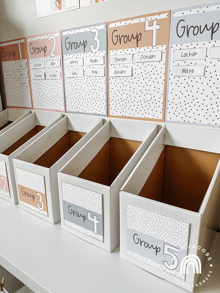 several boxes are lined up on a desk with dividers for each individual's groups