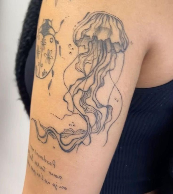 a woman's arm with a jellyfish tattoo on the left side of her body