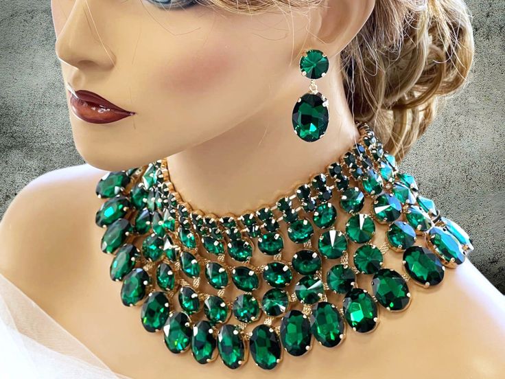 Crafted for the boldest of queens, this exquisite Emerald Green Chunky Wedding Necklace & Earrings Jewelry Set is a captivating masterpiece that exudes glamour with every wear. The set features high-quality materials, including shimmering crystals and lustrous beads, adding a touch of luxury to your ensemble. The bib necklace makes a bold statement piece, perfect for weddings, ballroom events, and drag performances, while the accompanying earrings enhance the overall allure. This jewelry set is Western Jewelry Necklace, Ballroom Jewelry, Ombre Necklace, Shoulder Jewelry, Queen Jewelry, Beautiful Costumes, Green Ombre, Perfect Palette, Necklace Statement