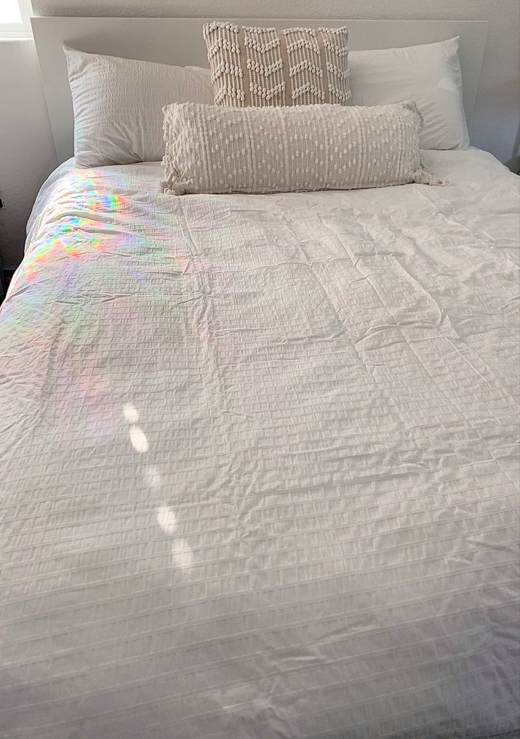 a white bed with two pillows on top of it