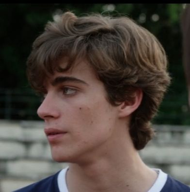 a close up of a person wearing a polo shirt and looking off into the distance