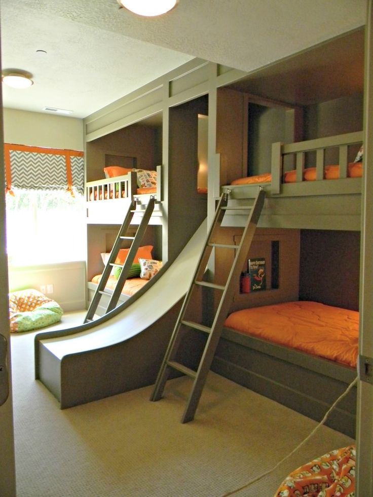 a room with bunk beds and a slide in the wall next to it is shown