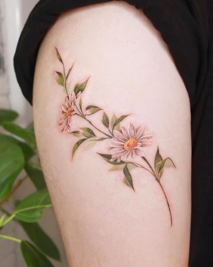 a woman's thigh with flowers and leaves on the side, in front of her