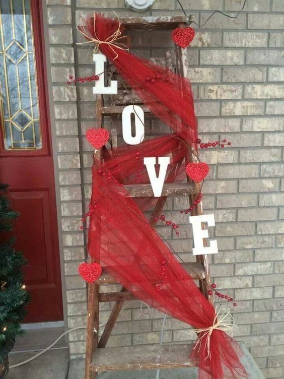 an old ladder decorated with red tulle and hearts for valentine's day on the front porch