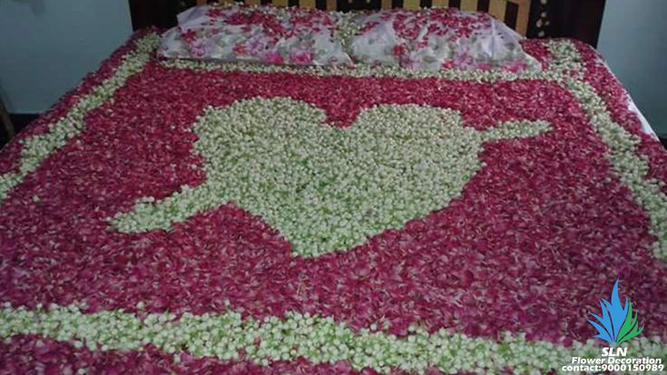 a bed covered in flowers with a heart on the comforter and pillow case next to it