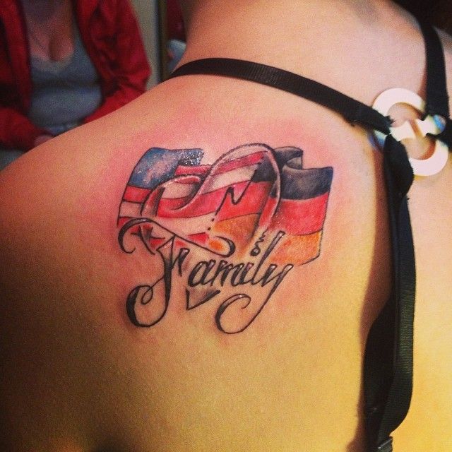 the back of a woman's shoulder with an american and german flag tattoo on it