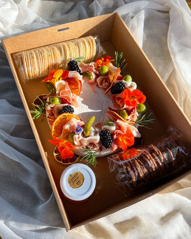 a box filled with fruit and pastries on top of a bed