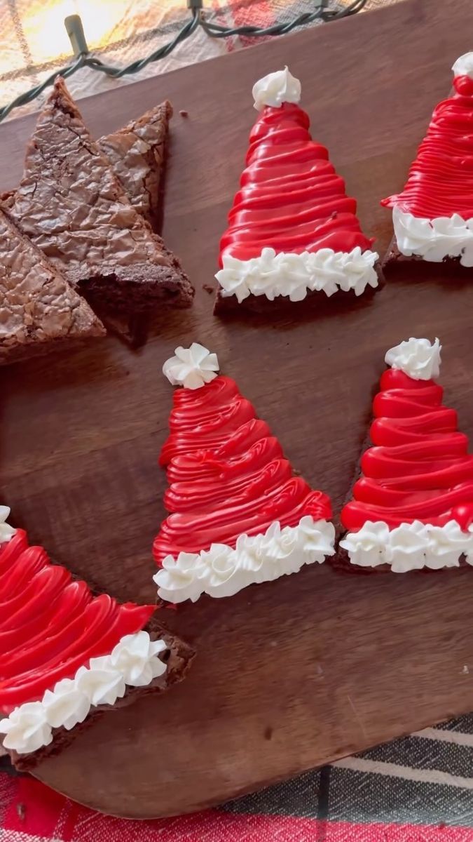 some red and white decorated cookies on a wooden board with christmas trees in the middle