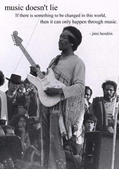 a black and white photo of a man with a guitar in front of a group of people