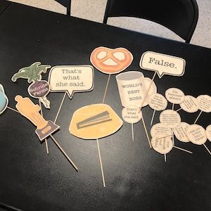 there are some paper cutouts on the table with words and pictures attached to them