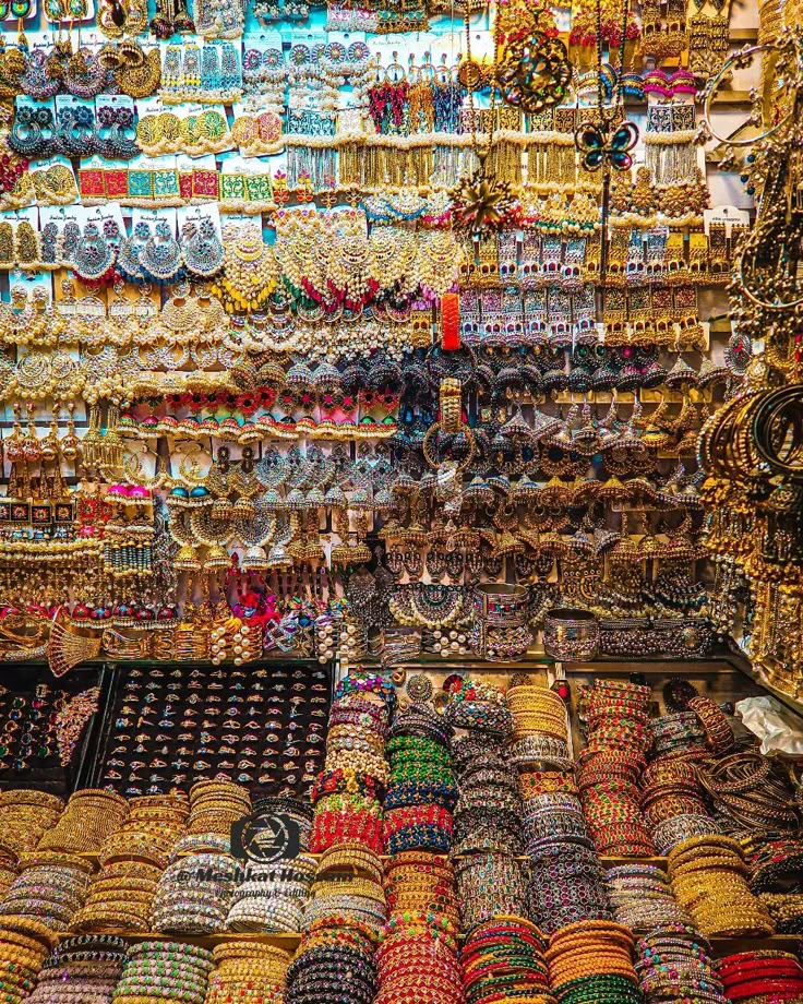 many bracelets and necklaces on display in a store