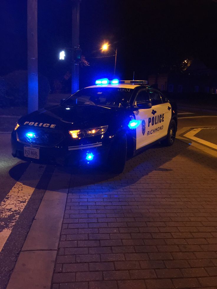 a police car is parked on the side of the road at night with its lights on