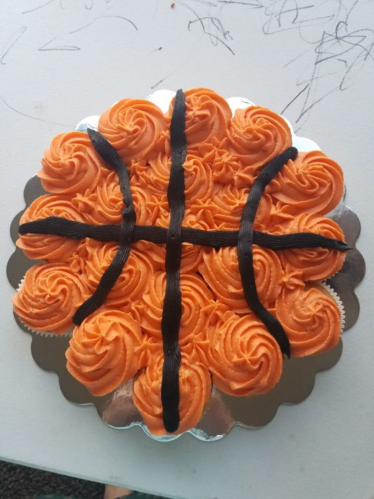 a basketball shaped cupcake with orange frosting and black ribbon around it's edges