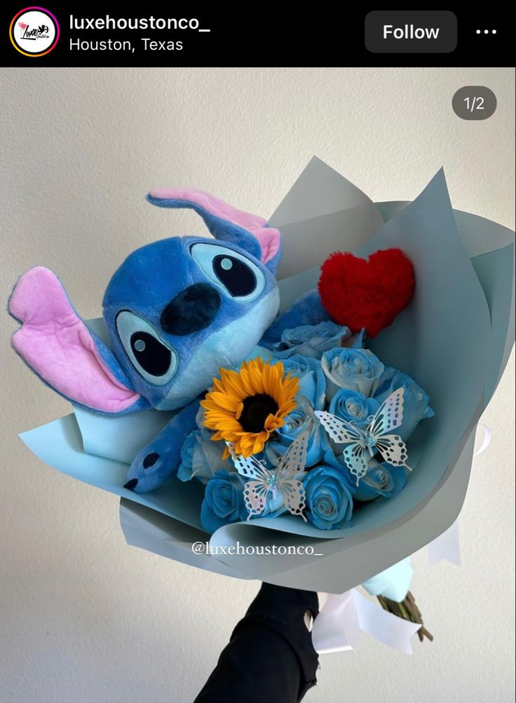 someone is holding a bouquet of flowers with stitchy stuffed animals in the center and heart on top