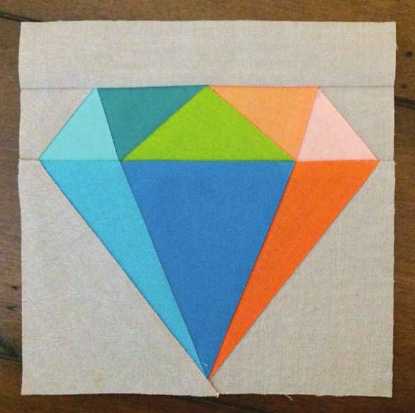 a piece of paper with an orange, blue and green diamond cut out of it