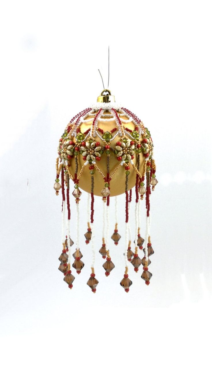 an ornament hanging from the ceiling with beads and chains on it's sides