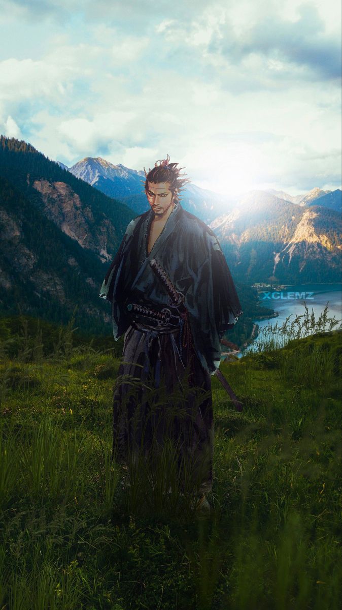 a man standing on top of a lush green field next to a mountain covered in clouds