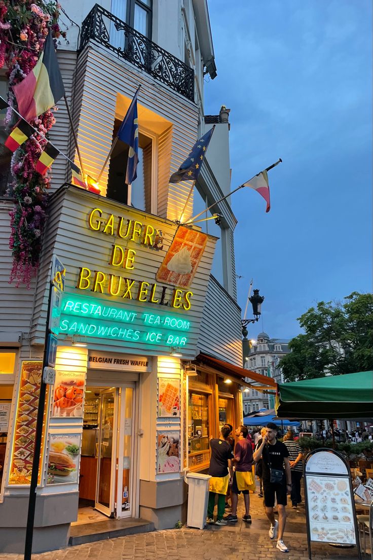 people walking in front of a restaurant called gauer de bruxeles