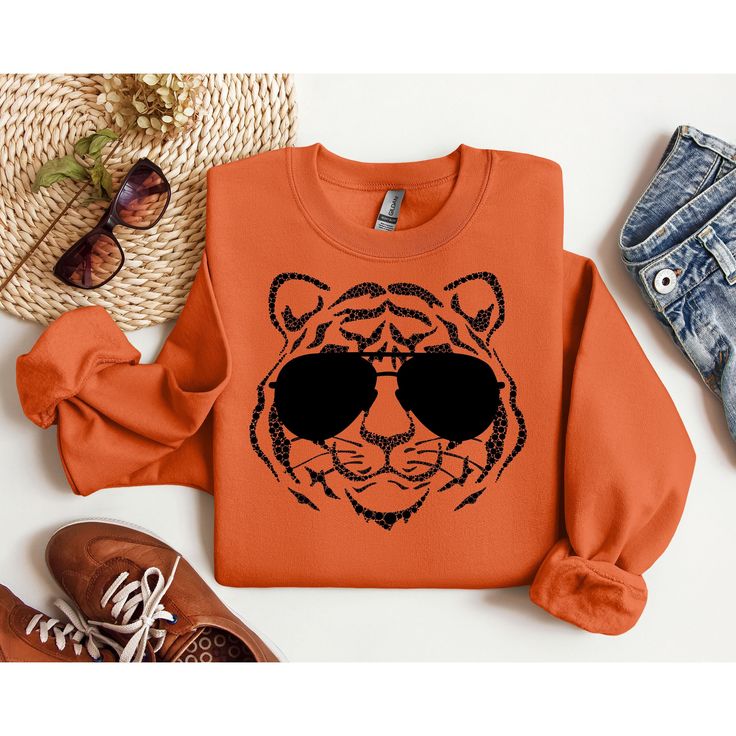 Are you a dedicated Cincinnati Bengals fan looking to step up your game day style? Look no further! Our Cincinnati Bengals Sweatshirt is the perfect way to showcase your unwavering support for the team, stay cozy, and look effortlessly stylish. Whether you're cheering from the stands at Paul Brown Stadium, hosting a game day gathering, or simply watching from home, this sweatshirt ensures you're doing it with style. Don't miss the chance to elevate your fan wardrobe and make a bold statement of your Bengals pride. Order our Cincinnati Bengals Sweatshirt today and be the envy of your fellow fans! Perfect for game day, tailgating, or everyday wear, this sweatshirt is a must-have for any Bengals fan. Show your love for the team and the Queen City in style with this fantastic addition to your Game Day Fan Apparel Top With Ribbed Cuffs, Team-colored Sweatshirt With Team Logo For Fall, Team-colored Fall Sweatshirt With Team Logo, Fall Varsity Sweatshirt With Team Logo, Varsity Sweatshirt With Graphic Print For Fans, Varsity Graphic Print Sweatshirt For Fan Gear, Fall Fan Gear Sweatshirt With Graphic Print, Fan Gear Graphic Print Sweatshirt For Fall, Fall Fan Gear Graphic Sweatshirt