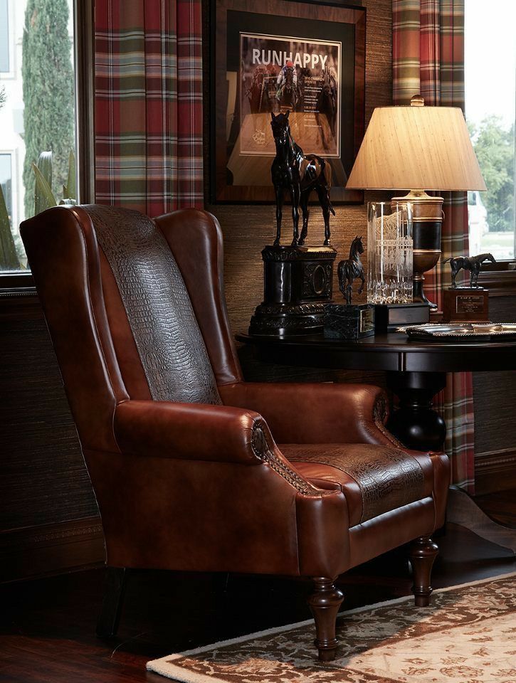 a brown chair sitting in front of a window next to a lamp