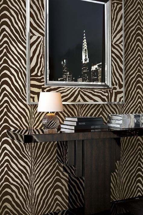 a zebra print wallpaper in a room with a table and lamp next to it