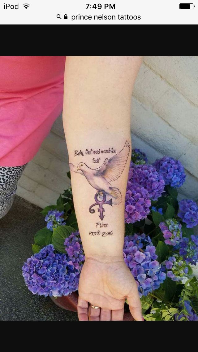 a woman's arm with a tattoo on it and flowers in the back ground