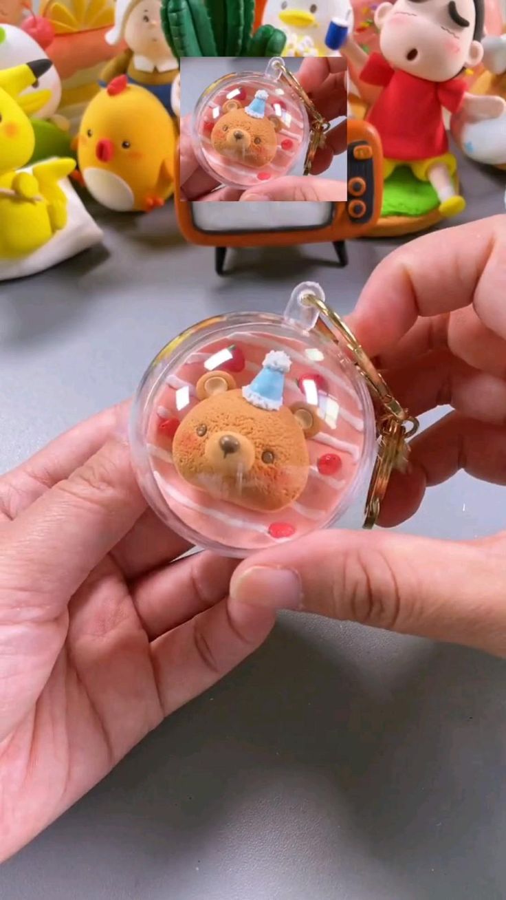 a person holding a small glass ornament with a bear on it's face