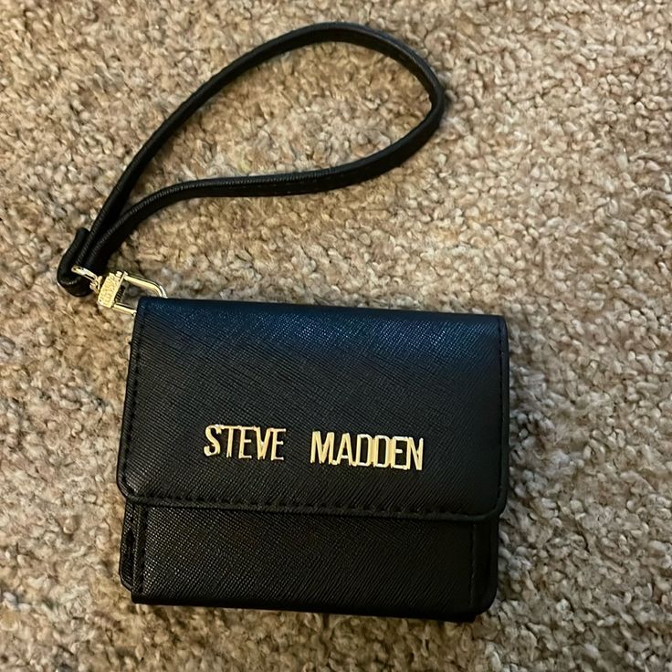 a small black wallet with the name steve maden on it is laying on the floor