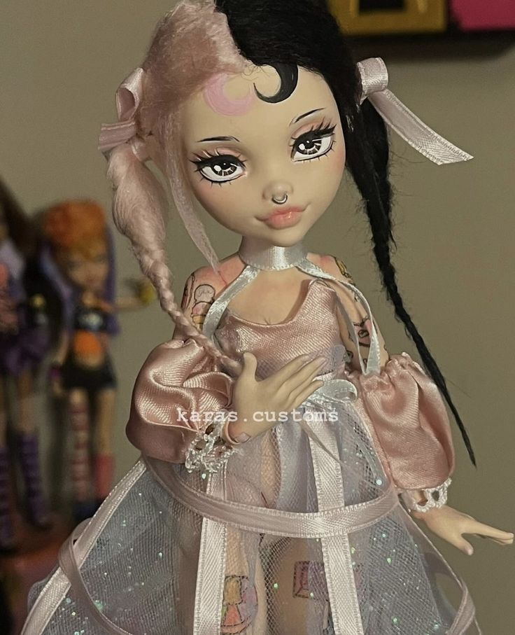 a doll with black hair wearing a pink dress