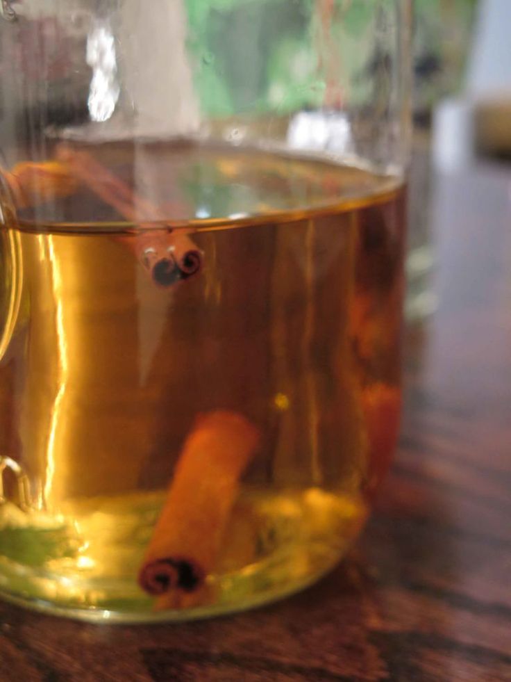 a glass cup filled with liquid sitting on top of a wooden table