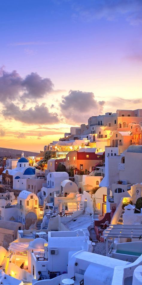 the sun is setting over a city with white buildings and blue sky in the background